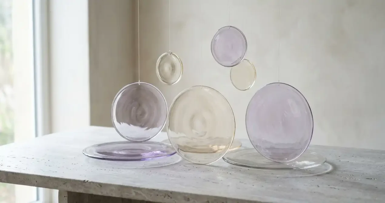 Abstrakta glasformer i mjukt ljus mot en lugn neutral bakgrund